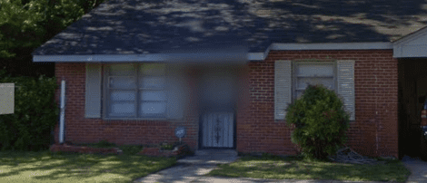 Brick house with a front door and yard.