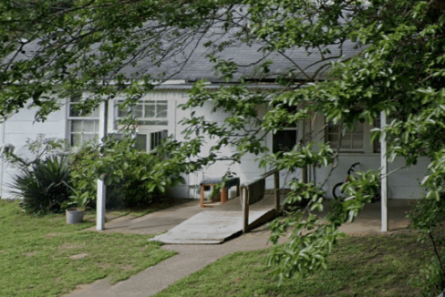 White house with ramp and bike.