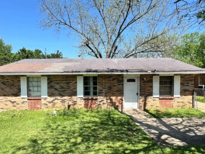 Brick house with front yard and trees.