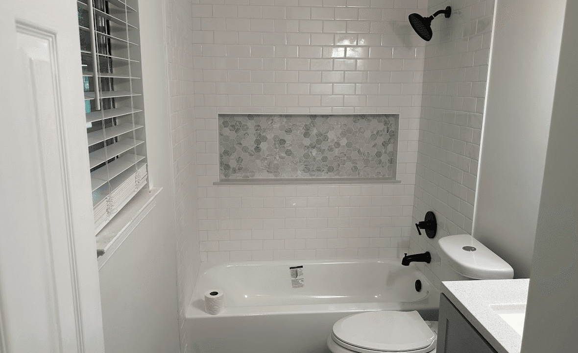 White bathroom with bathtub and floral tiles.
