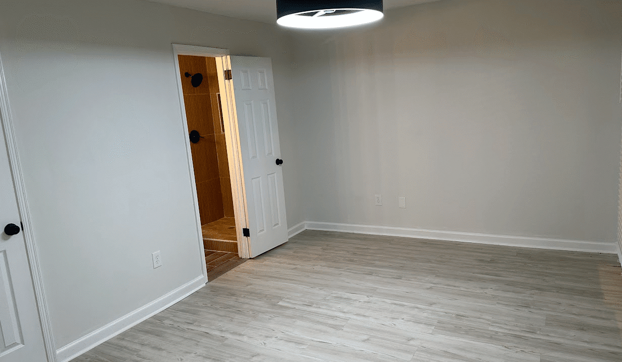 Empty room with wooden floor and light fixture.