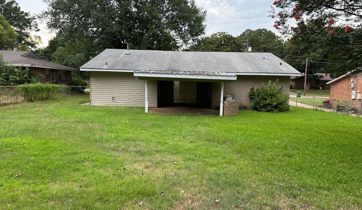 Small house with overgrown front yard.