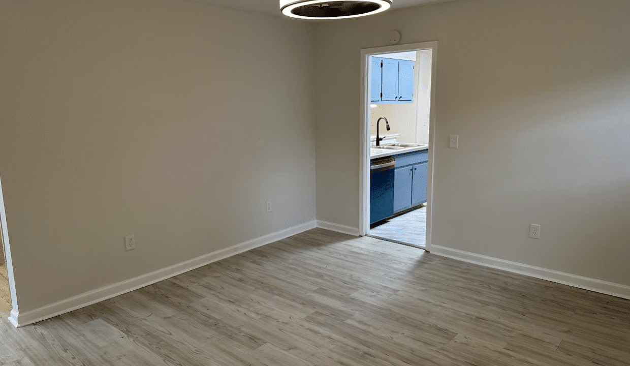 Empty room with doorway to kitchen area.
