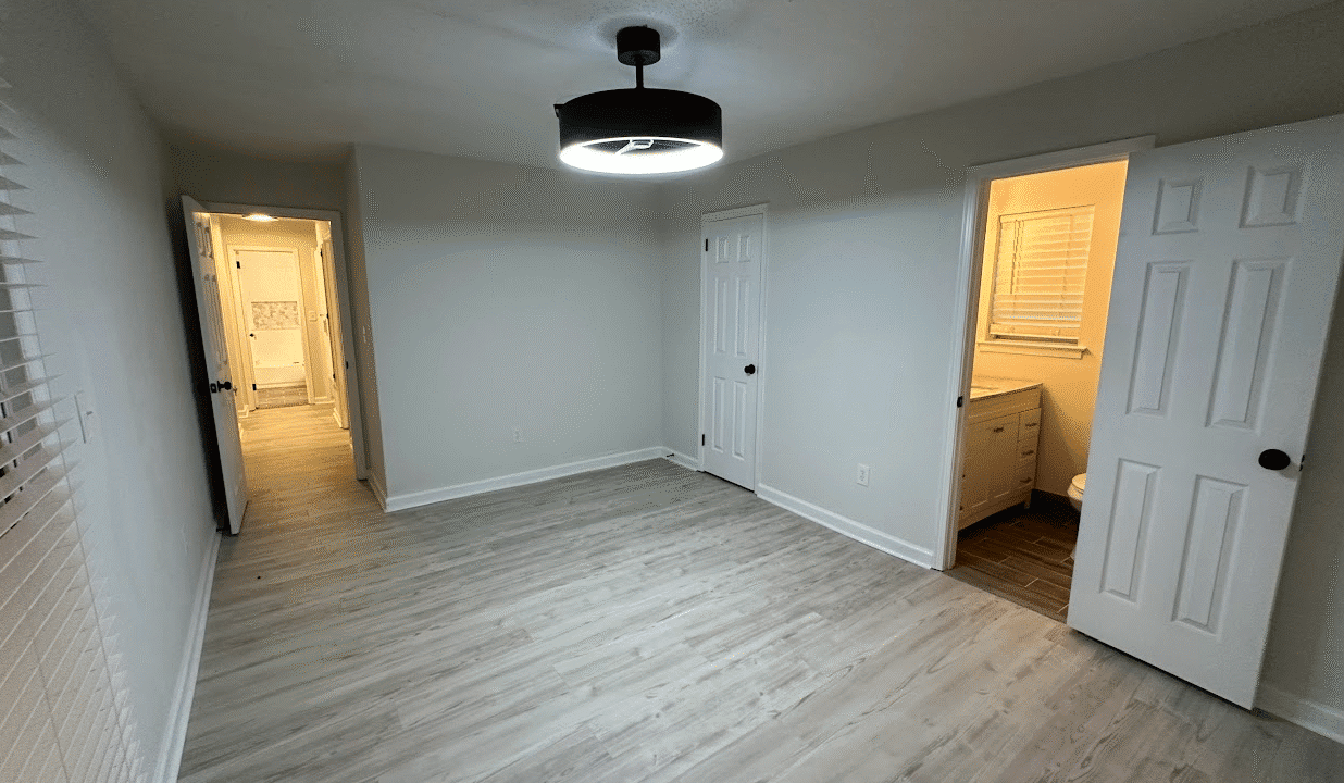 Empty room with light wood flooring.