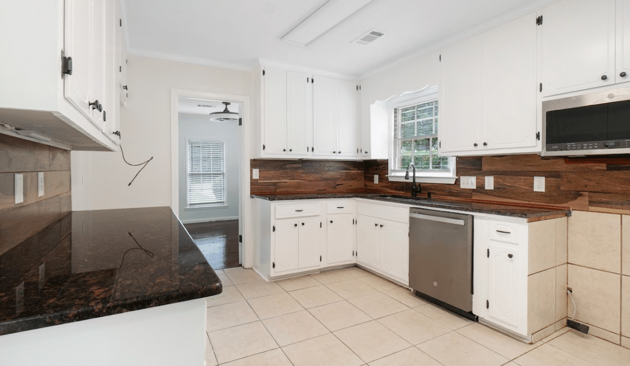 Modern kitchen with white cabinets and appliances.