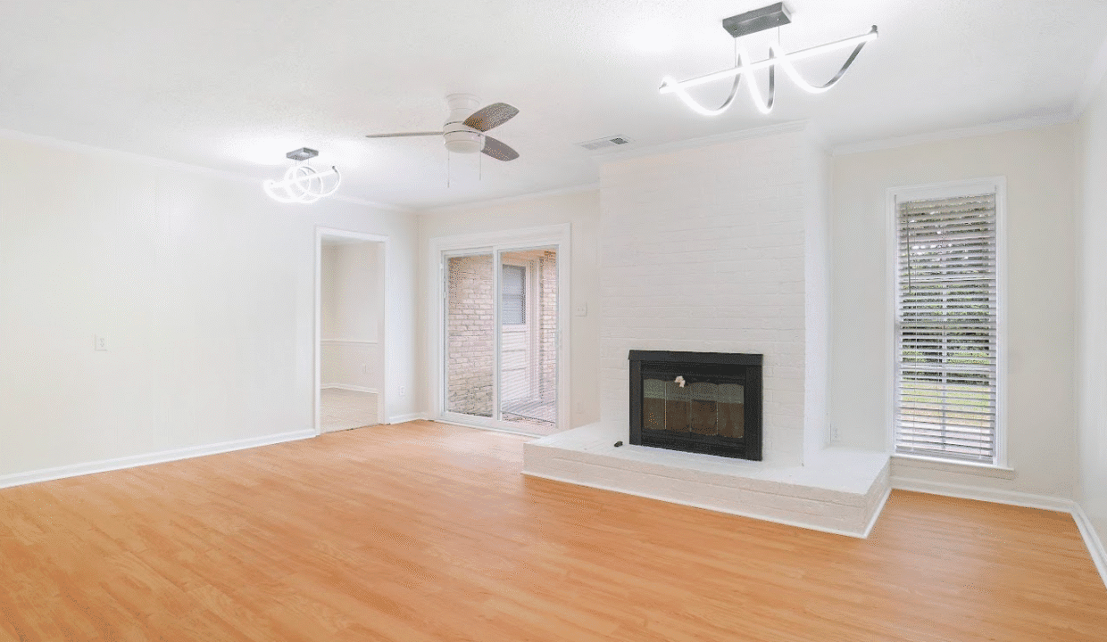 Spacious living room with fireplace and ceiling fan.