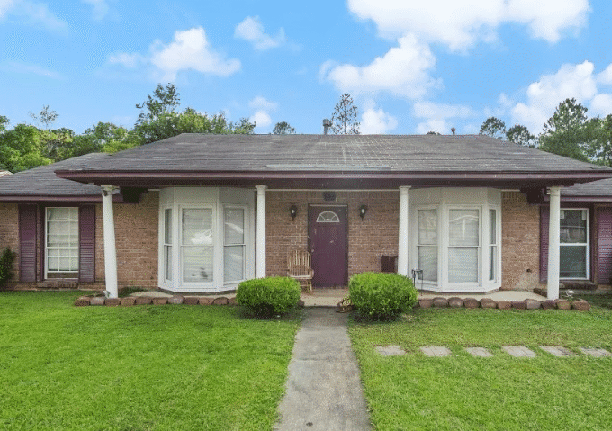 Brick house with white trim and lawn.