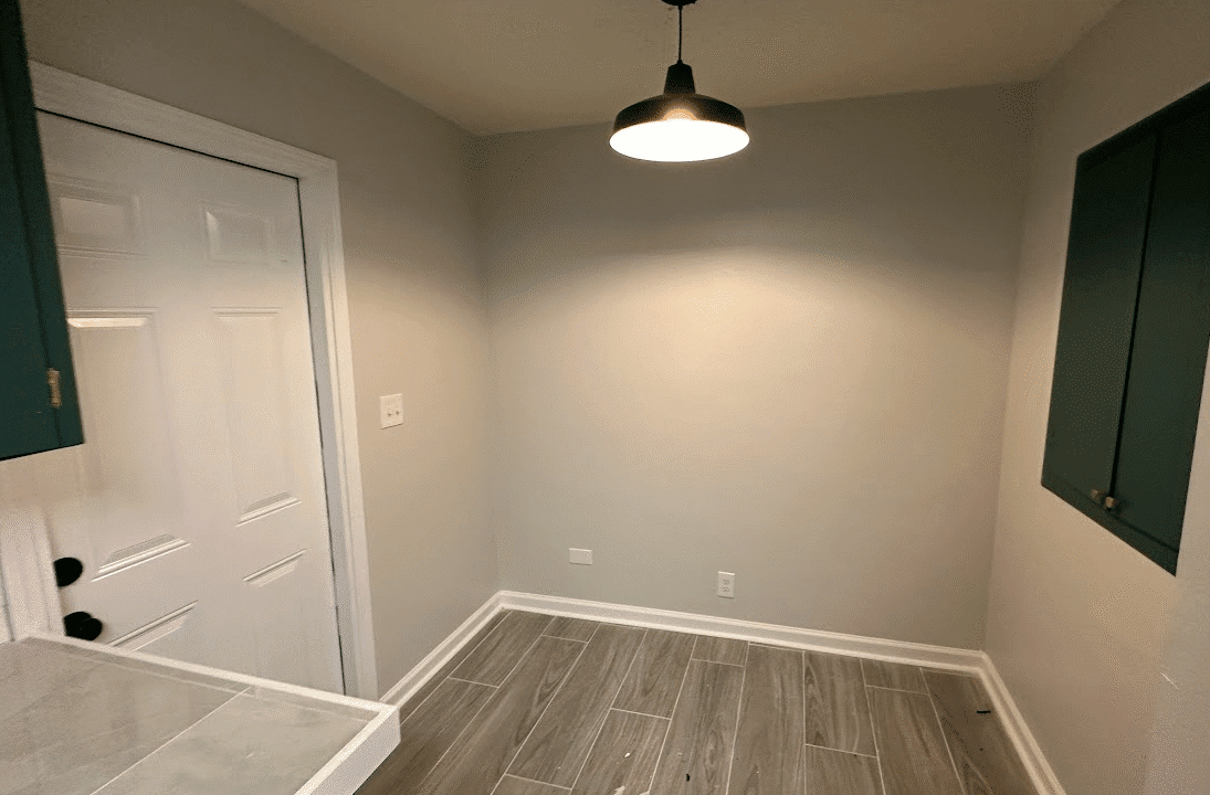 Small empty room with hanging light fixture.