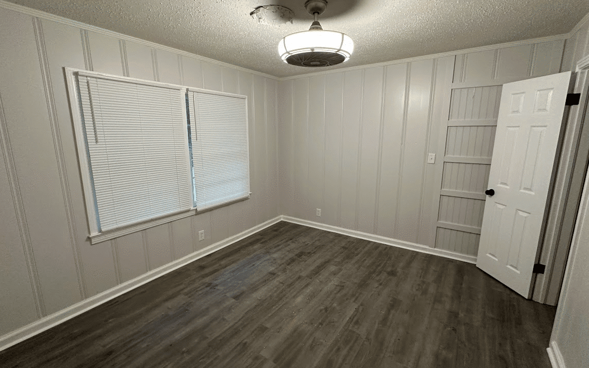 Empty room with wood floor and window.