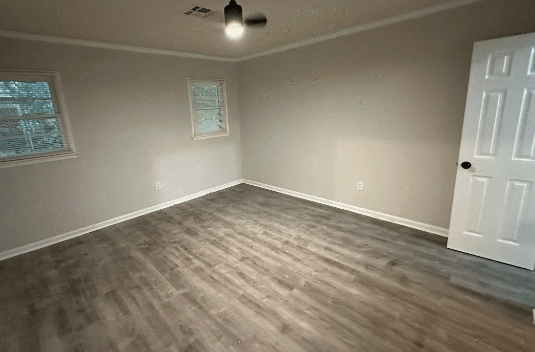 Empty room with wooden floor and windows.
