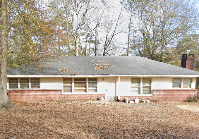 Single-story house surrounded by autumn trees.