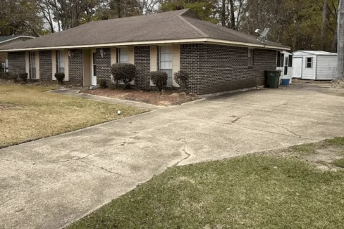 Single-story brick house with front yard.