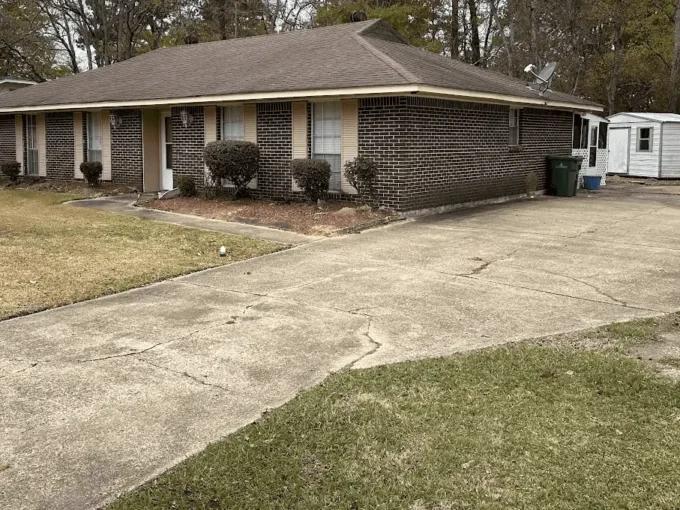 Single-story brick house with front yard.