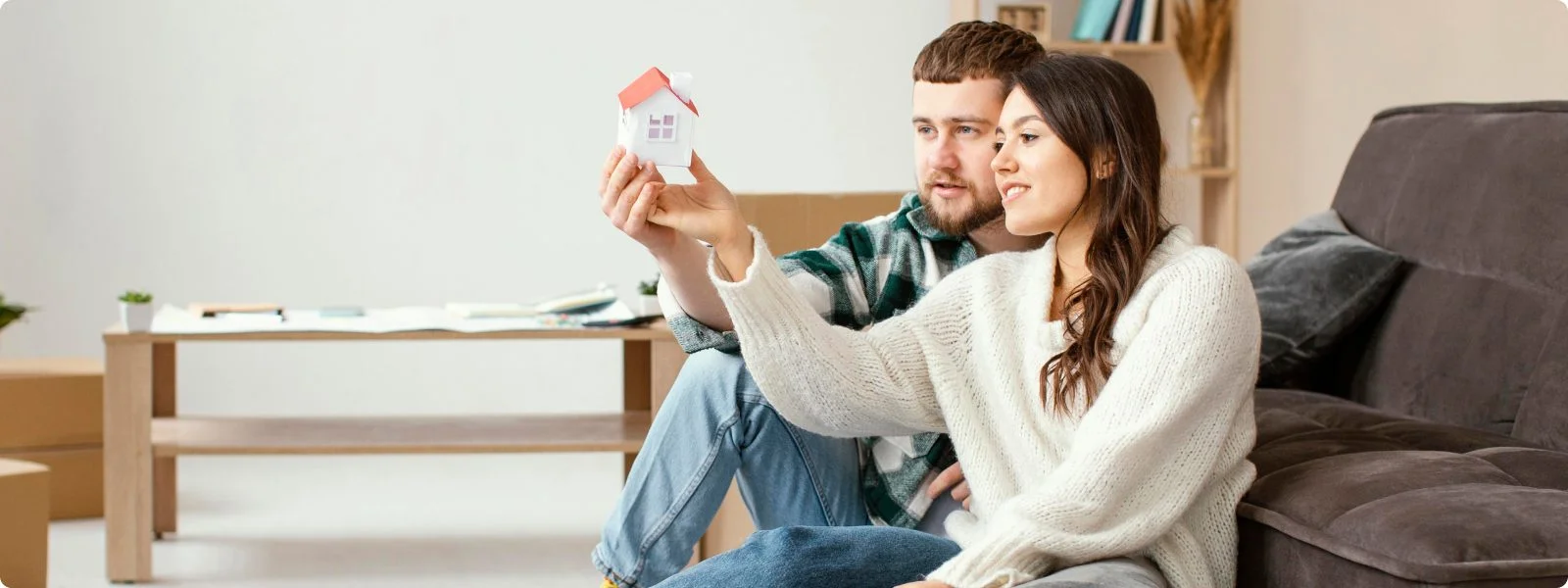 Couple holding small model house together